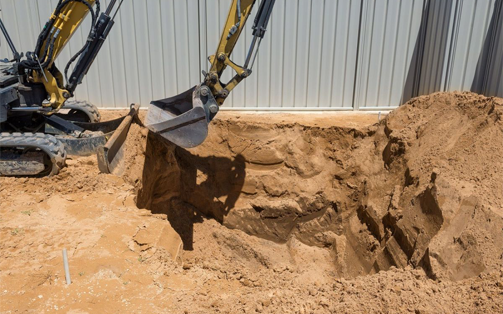 Excavation de terre avec une pelleteuse sur un chantier, avant la phase d'évacuation terres