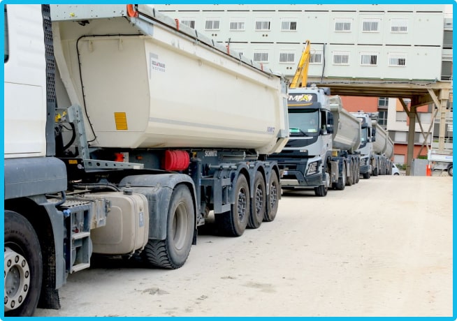 Plusieurs camions à l'entrée d'un chantier, pour une gestion des déchets optimale